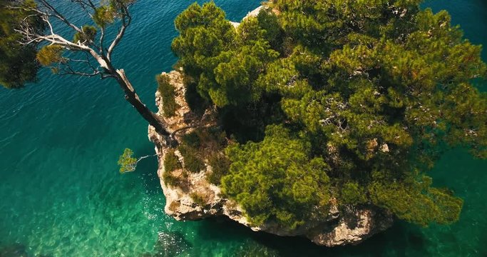 aerial shot of the famous little paradise rockisland in brela / croatia / europe. super wide shot, camera moves towards and then over the island with view to the ground.
