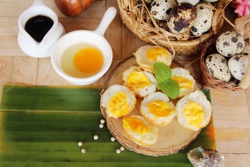 Grilled eggs with sauce on wood background