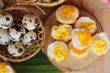 Grilled eggs with sauce on wood background