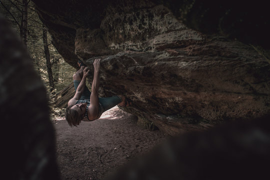 Mann beim bouldern am Fels 