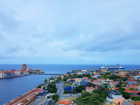 aerial view of the coastline city of Willemstad, capital of Curazao, with colorful buildings and blue sea and sky.