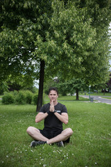 Naklejka na ściany i meble young man in park meditating 