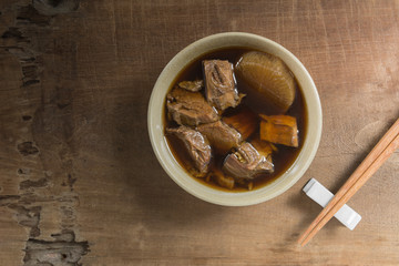 top view of asian style tender boiled beef soup in a ceramic bowl on old and crack wooden table. healthy food concept.