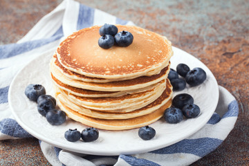 Delicious pancakes close up, with fresh blueberries on rusty background. Top view