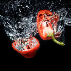 close up view of bell pepper pieces in water isolated on black