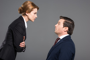 angry female boss looking at scared businessman, isolated on grey, feminism concept