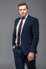 Fototapeta premium handsome serious businessman posing in formal wear, isolated on grey