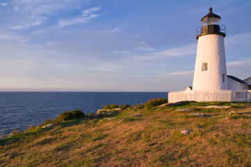 Fototapeta na wymiar White Lighthouse On Shore in Early Morning