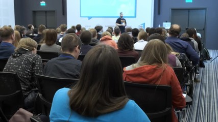 Representatives of the political and financial organizations in full hall are listening to the speaker speech about marketing and management of trading companies for successful sales. Close up indoors