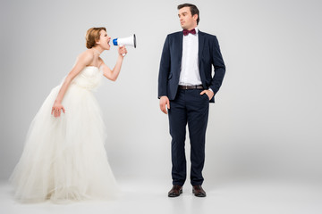angry bride with megaphone yelling at groom, isolated on grey, feminism concept
