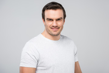 portrait of handsome man smiling at camera, isolated on grey