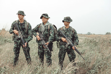Soldier ready his weapon. Standing up holding their assault rifle. Portrait full body shot. Digital...