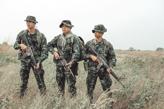 Soldier ready his weapon. Standing up holding their assault rifle. Portrait full body shot. Digital green camo. - Powered by Adobe
