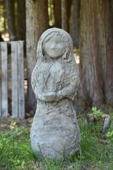 Girl holding dish burlap and cement statue