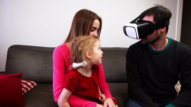 The father of the family sits in the virtual reality helmet