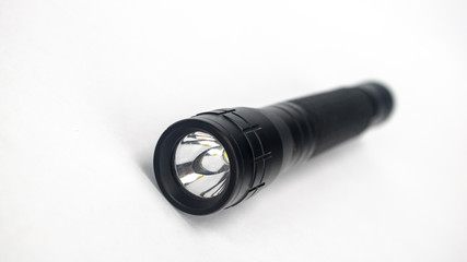 A black flashlight on an isolated white background