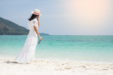 a beautiful carefree Woman relaxing at the beach enjoying her sun dress freedom wear.