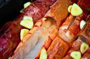 Norwegian lobster, also langoustine, scampi (lat.Nephrops norvegicus), raw in marinade with garlic and pesto sauce. Decorated with a sprig of dill. Ingredient for cooking. Dietary or vegetarian dish.
