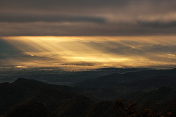 Golden sunrise heavenly sky ray light at mountain hill valley landscape with cloudy background