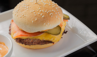 Burger on a plate with fried potatoes and sauce