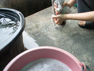 Fototapeta premium Girls wash the laundry beside the house to clean the house.