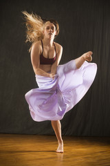 Young woman dancing in the studio on a hardwood floor.