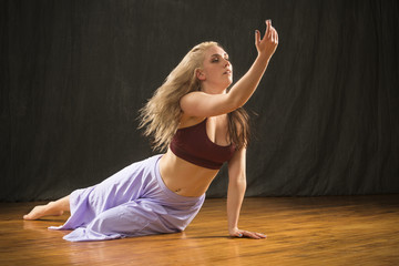 Young woman dancer performing dramatic floor work.