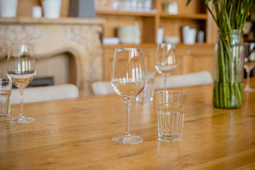 Empty glasses set in restaurant. Part of interior. Selective focus.Restaurant table with glasses and cutlery, fireplace on background.Transparent clean glasses and wine glasses.