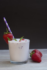 Milk Cocktail Shake Drink with Srawberry. homemade Fruit Milkshake with Straw in Glass. Rustic Gray wooden Background.
