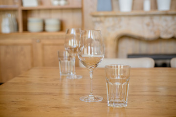 Empty glasses.Transparent clean glasses and wine glasses arranged on a wooden table in restaurant or bar.restaurant interior.focus view on empty water and wine glasses served for holiday dinner table