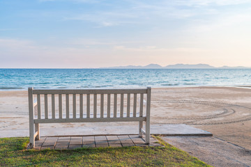 Fototapeta na wymiar Relaxing white wooden bench at seafront with beautiful sea and mountain.