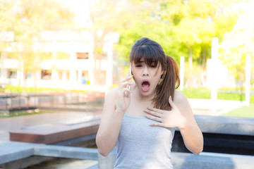 Portrait shocked beautiful woman: Attractive girl get surprised and shocking when her family tell her a bad news from oversea. Pretty girl feel sad, painful her mind and screaming, sunlight background