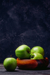 Apples are green in a bowl on the table