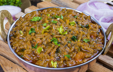 Indian Cuisine Sev Tamatar Also Called Sev Tamaeta or Sev Tameta is Served With Chapati, Papad, Onion or Raita. It is Made With Tomato And Onion Gravy With a Twist of Spicy Sev on Wooden Table
