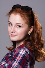 Fototapeta premium Portrait of smiling girl with sunglasses on head looking at camera