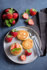 Cottage cheese pancakes with strawberry on blue concrete table background. Breakfast or Lunch Concept. Top view