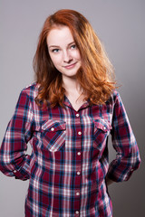 Fototapeta premium Portrait of a cheerful young woman in a plaid shirt.
