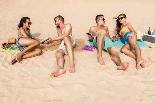 Group of friends lying at the beach taking a sunbath