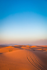 Fototapeta na wymiar Tracks on the sand dunes, in the desert by Al Wasil, Oman.