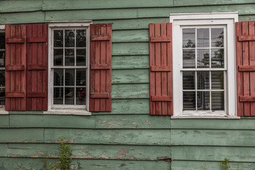 Fototapeta na wymiar JUNE 26, 2017 - SAVANNAH GEORGIA - Historic siding of home features red shudders and green siding old wood - 