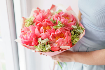 Lovely flowers in glass vase. Beautiful bouquet of peonies sort of coral charm. Floral composition, scene, daylight. Wallpaper