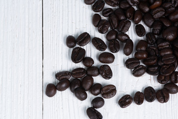 Roasted coffee beans on white wood table. coffee background with copy space.