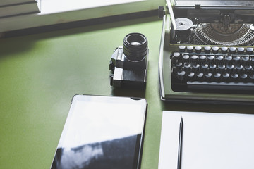 Analog Typewriter, Digital Tablet And Film Camera On The Green Table, Top View. Journalism Writing Concept