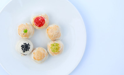 Spring roll pastry with nuts and salted eggs, chinese pastry on white plate against white background.