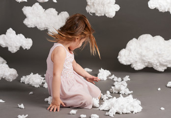 girl playing with clouds, shot in the studio on a gray background