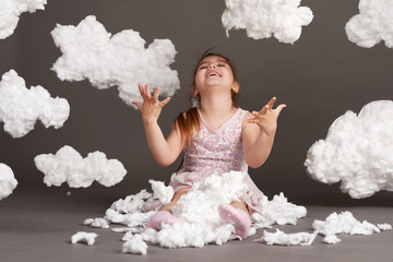 girl playing with clouds, shot in the studio on a gray background