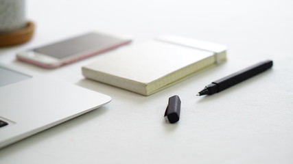 computer phone and notepad with white background table