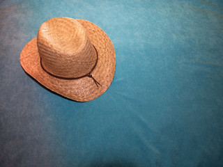 Fototapeta na wymiar Beach hat on turquoise blue towel. We go to the beach