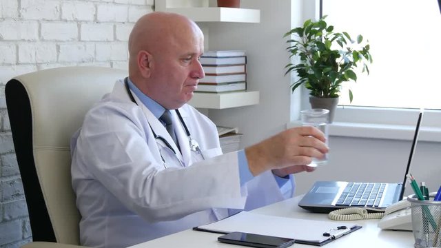 Thirsty Doctor in Hospital Office Room Working with Computer Drink Fresh Water