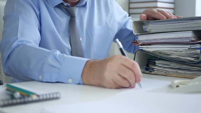 Businessman in Office Room Counting Files and Documents Writing on a Paper